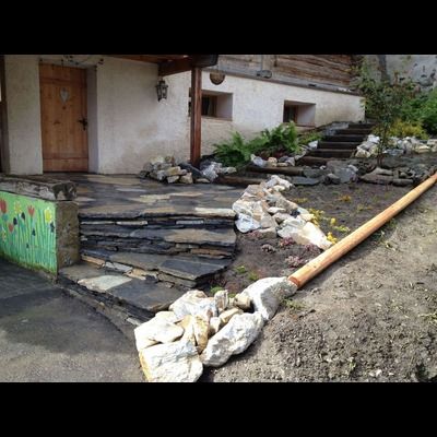 Une allée en pierre est en cours de construction devant une maison.