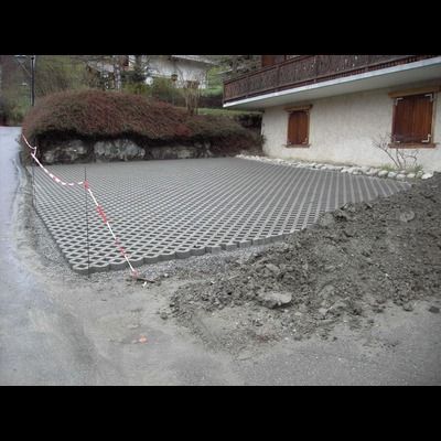 Une allée en béton est en cours de construction devant une maison.