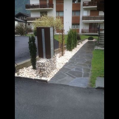 Une allée en pierre menant à un bâtiment avec un bâtiment en arrière-plan.