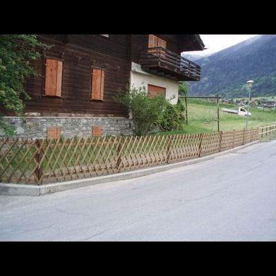 Une maison avec une clôture en bois devant elle
