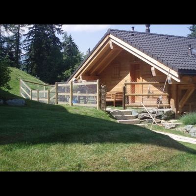 Une maison en bois avec une clôture devant