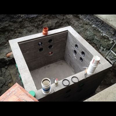 Une boîte en béton avec des trous est en train d'être construite dans la terre.