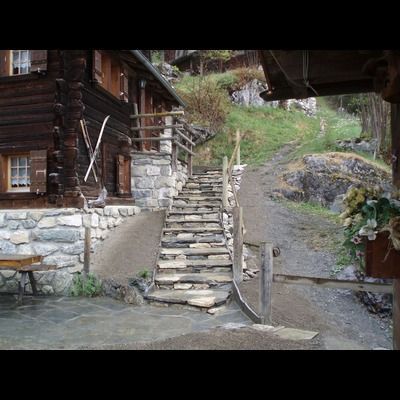 Un escalier en pierre menant à une maison en bois