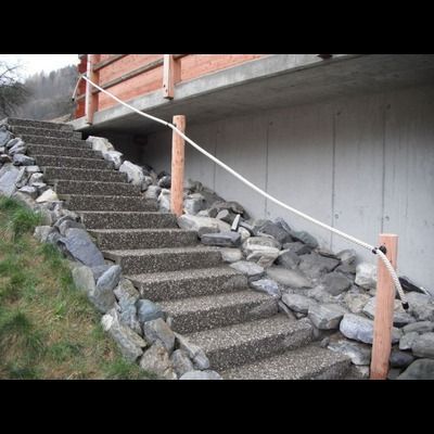 Un escalier menant à un bâtiment avec une balustrade en corde