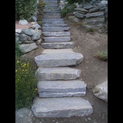 Une rangée de marches en pierre menant à un mur de pierre.