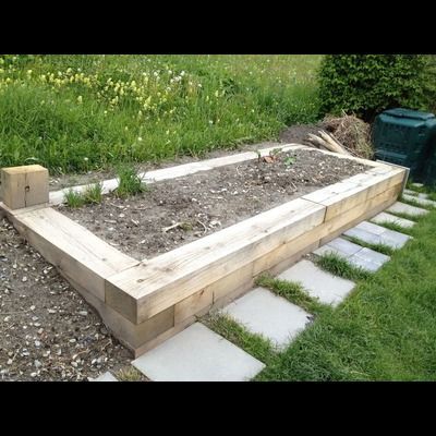 Un parterre de jardin en bois se trouve au milieu d'un champ herbeux.