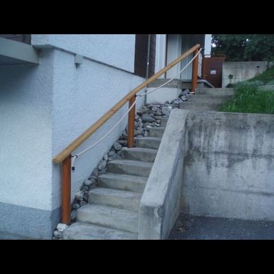 Escalier menant à une maison avec une rampe en bois
