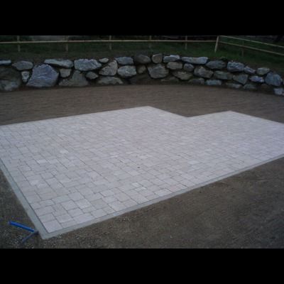 Une allée en briques avec un mur de pierre en arrière-plan