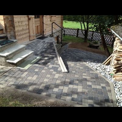 Une passerelle en pierre avec des escaliers menant à un bâtiment en bois