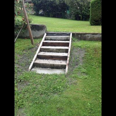 Un ensemble d'escaliers menant à une colline herbeuse dans une cour.