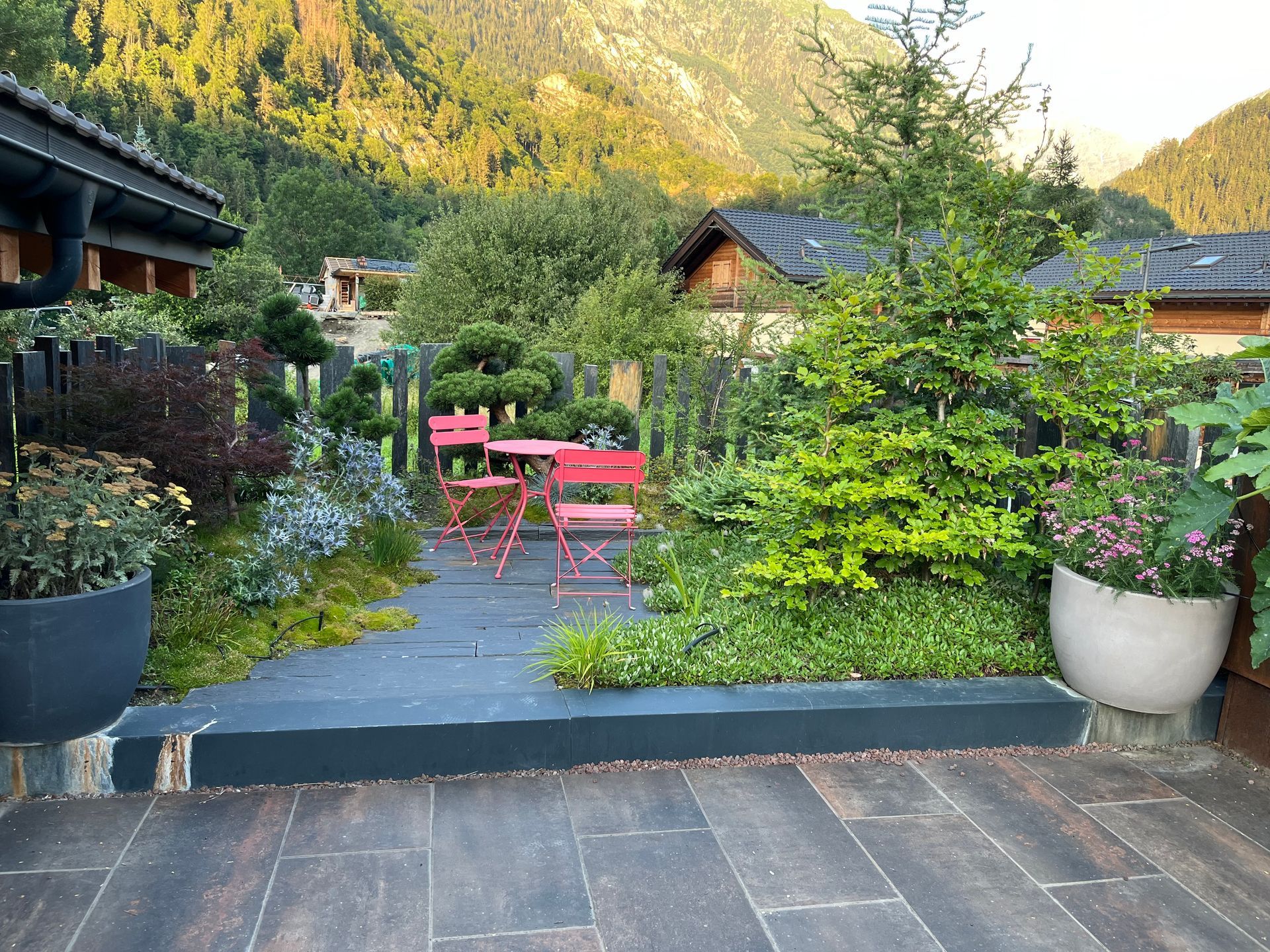 Une clôture blanche entoure une cour verte luxuriante.