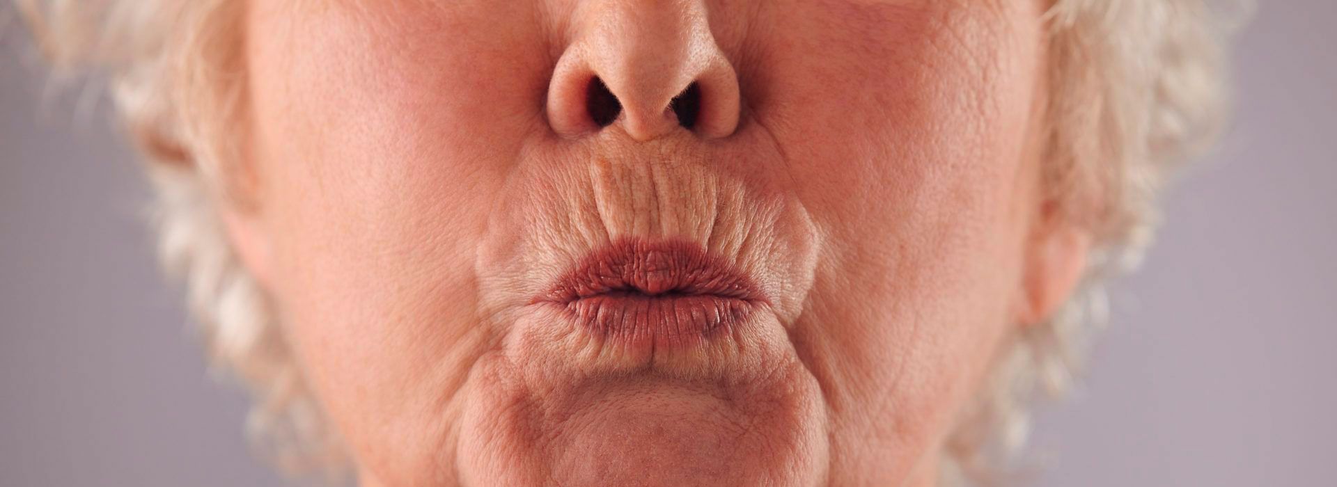 Un primer plano de una mujer mayor haciendo una mueca divertida.