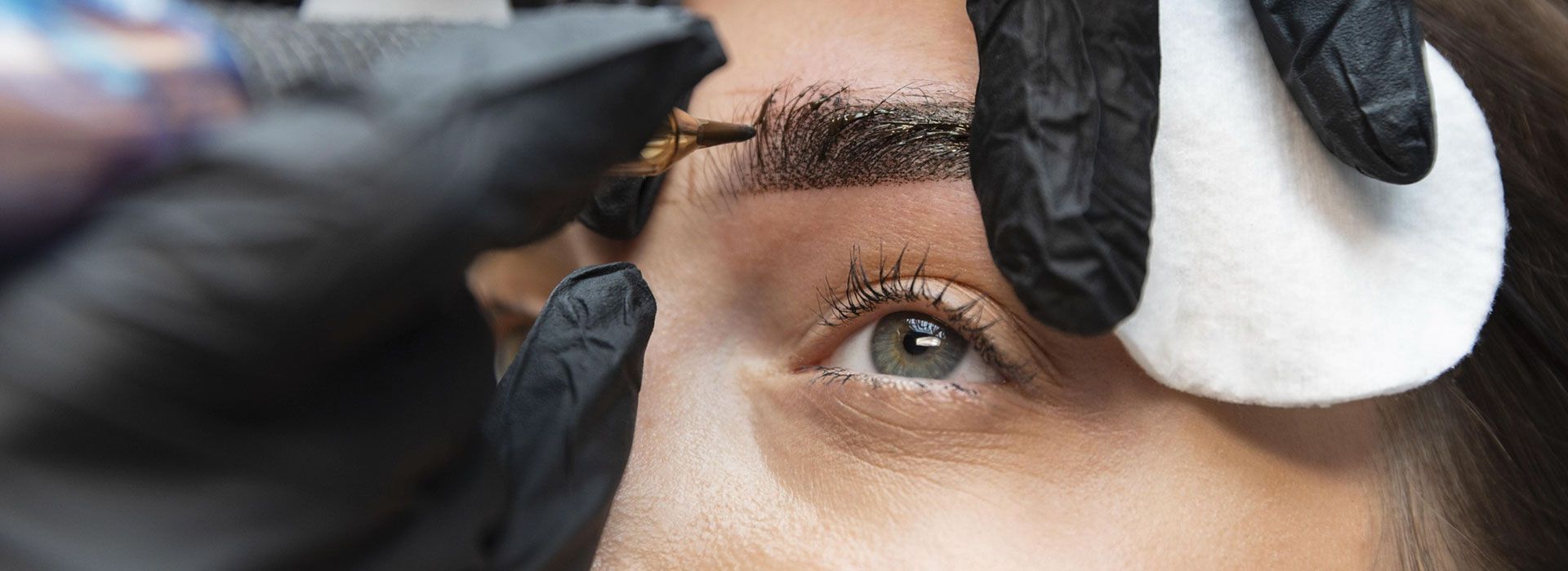 Un primer plano de una mujer pintándose las cejas.