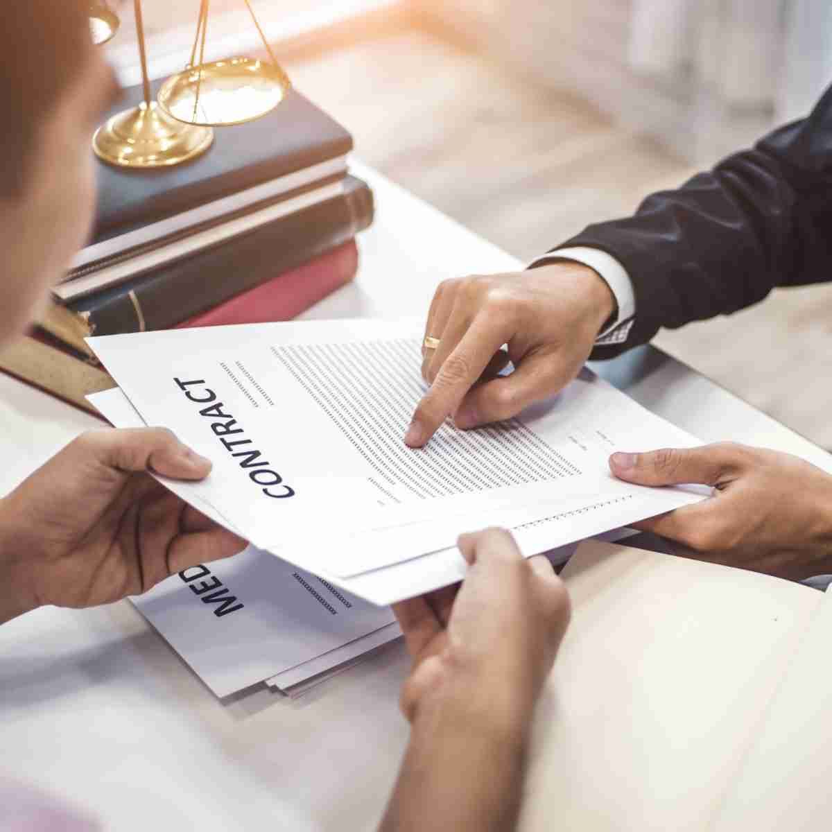Un hombre señala un trozo de papel con la palabra contrato.