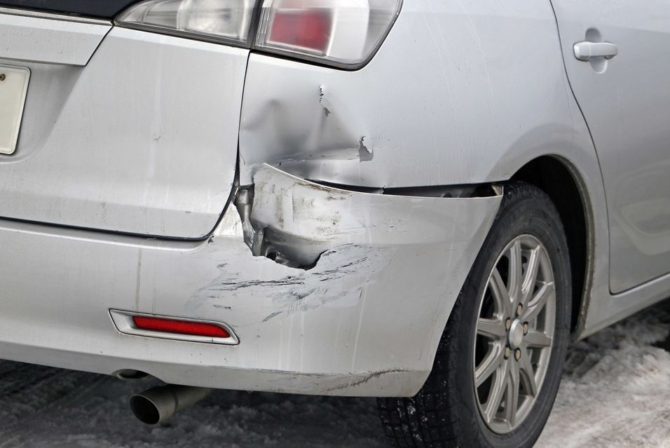 Nahaufnahme einer roten Motorhaube und eines schwarzen Kühlergrills mit Wabengitterdetail.
