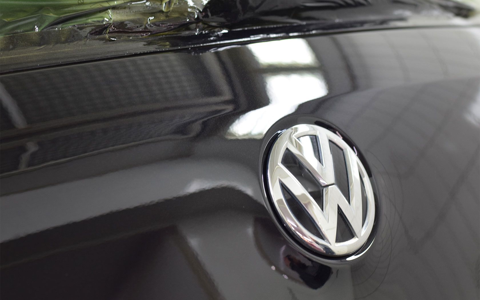 Nahaufnahme einer orangefarbenen Autokarosserie mit Parksensoren über einem schwarzen Kühlergrill