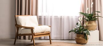 Stuhl vor einem Fenster mit Vorhängen