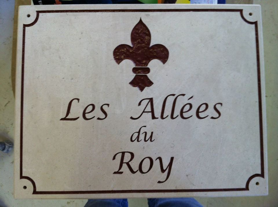 Signalétique Les Allées du Roy sur un marbre blanc