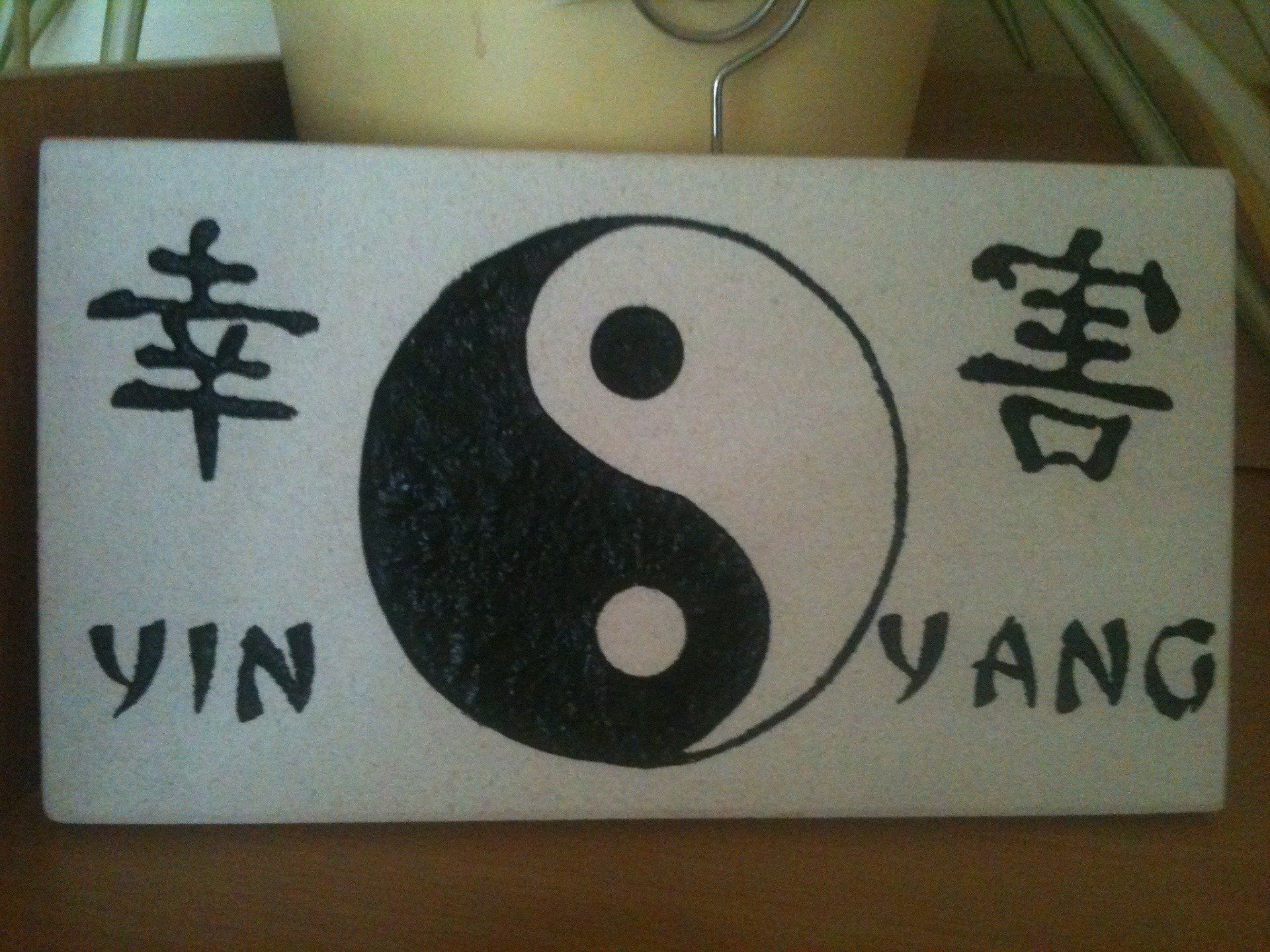 Yin et Yang gravé en noir sur plaque blanche