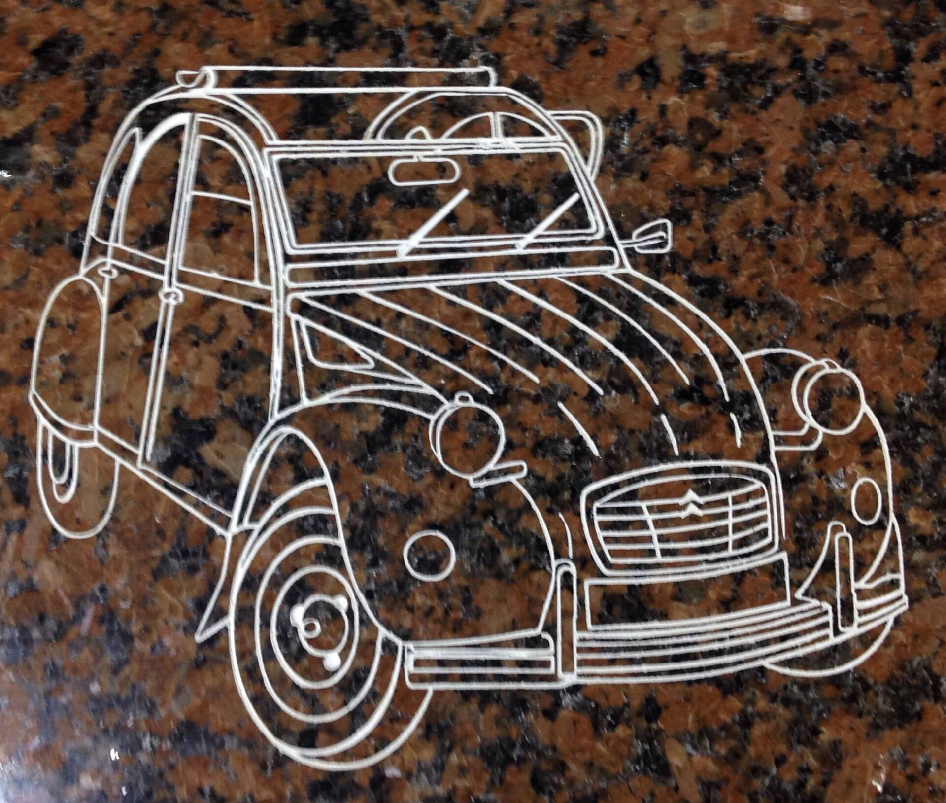 Gravure d'une deux-chevaux sur un marbre rouge et noir