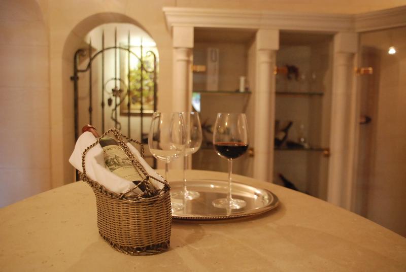 Cave à vin en pierre avec en premier plan un service à vin sur une table en pierre