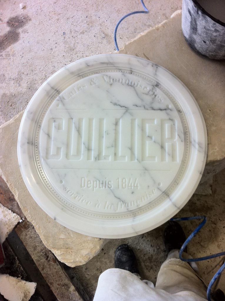 Gravure sur marbre d'un plat en marbre rond avant dorure