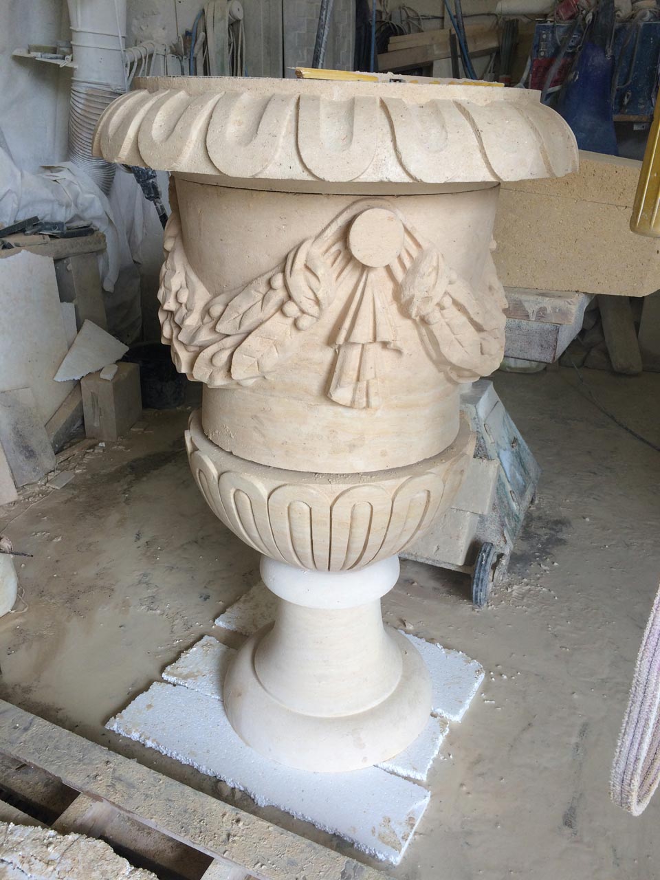 Énorme vase en pierre avec couronne de laurier sculpté dans un style classique