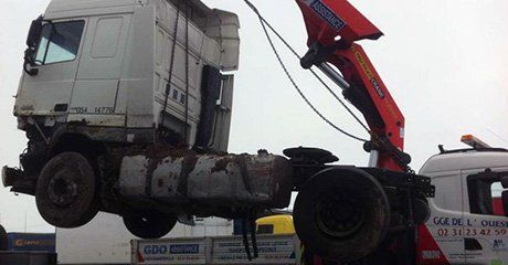 Un camion accidenté soulevé par une grue mobile