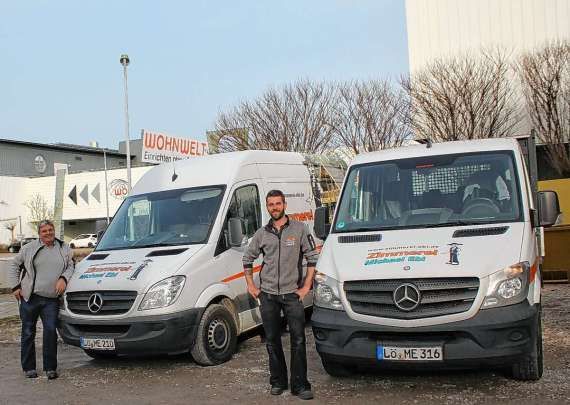 Zwei Männer stehen vor zwei Mercedes-Transportern.