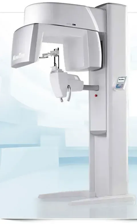 Una máquina de rayos X dental de color blanco está encima de una mesa blanca.