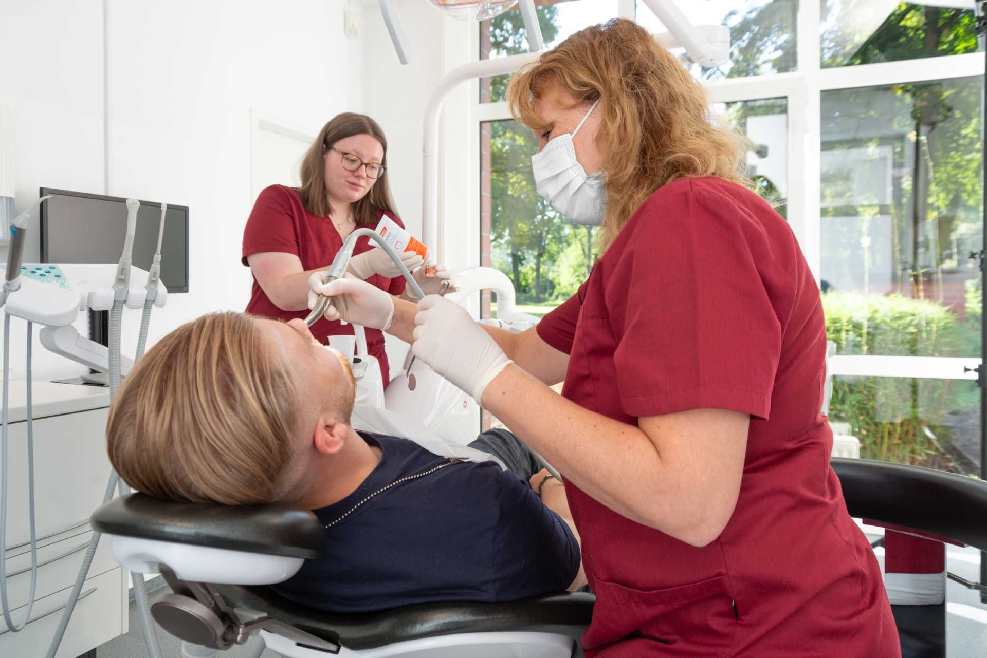Personal der Praxis Dr. Wiesemann untersucht die Zähne eines Patienten