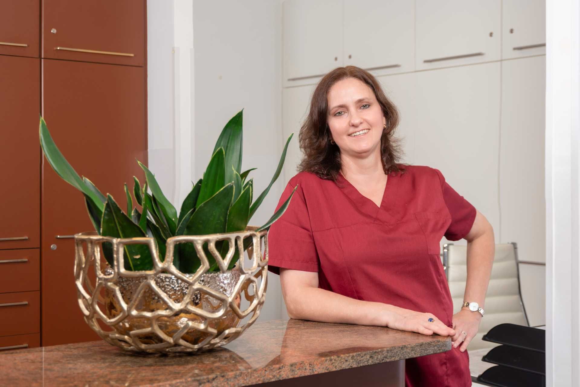 Dr. Wiesemann lehnt an der Rezeption in der Zahnarztpraxis