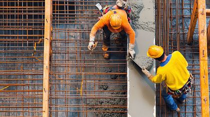 Eine Gruppe Bauarbeiter arbeitet an einem im Bau befindlichen Gebäude.