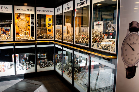 Intérieur de magasin de montres avec vitrines présentant des montres de plusieurs marques.