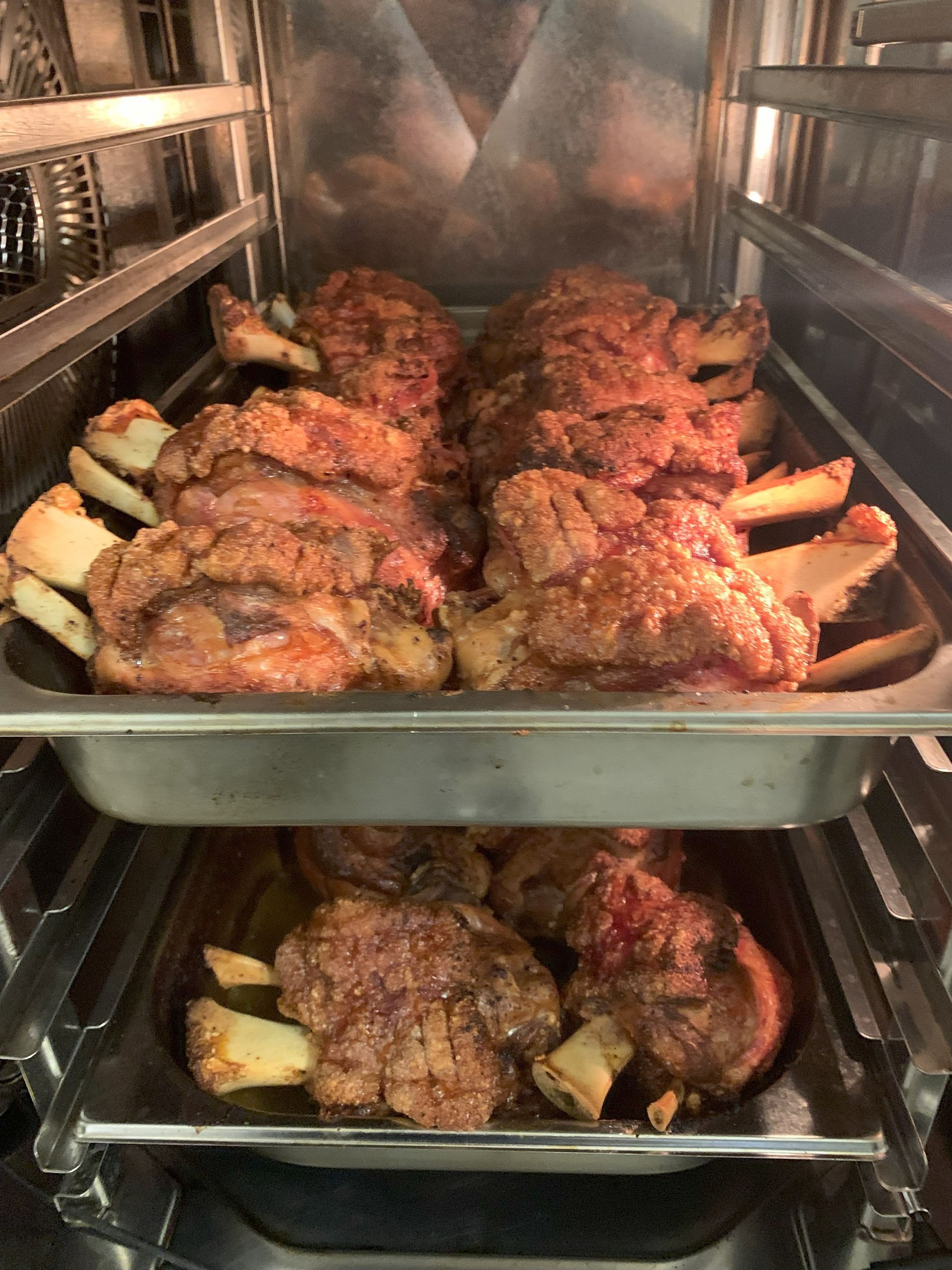 Gebratene Schweinshaxen auf zwei Backblechen.
