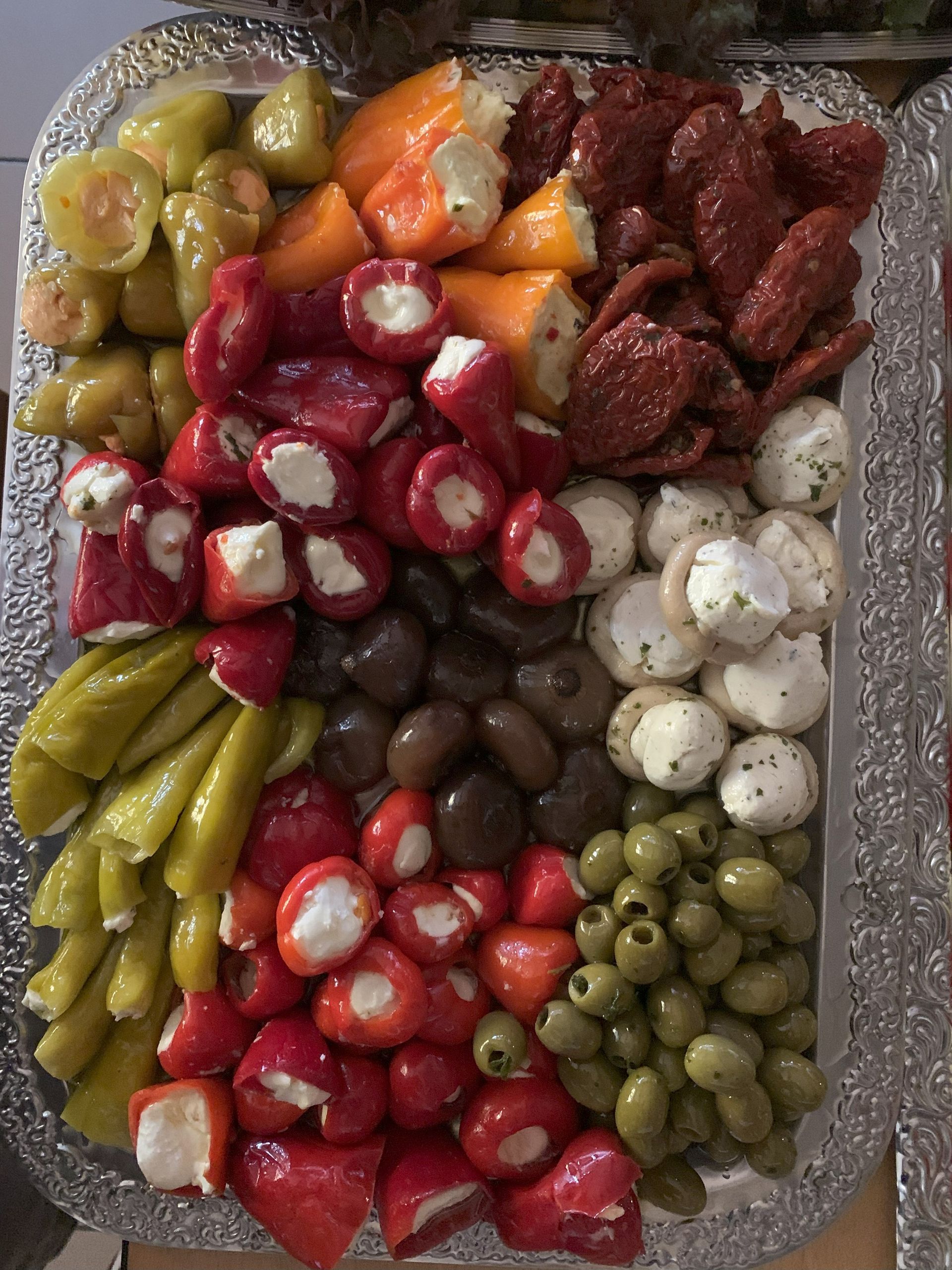 Vorspeisenplatte mit Paprika, Oliven, Käsebällchen und sonnengetrockneten Tomaten.
