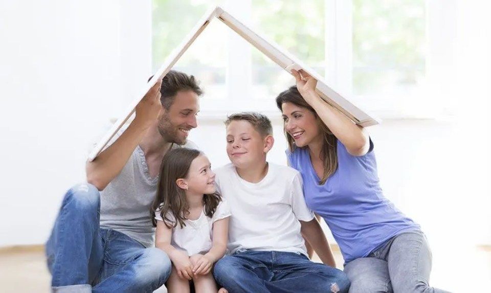 Familie unter gebasteltem Kartondach