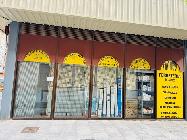 Un frente de tienda con un cartel amarillo que dice ferretería