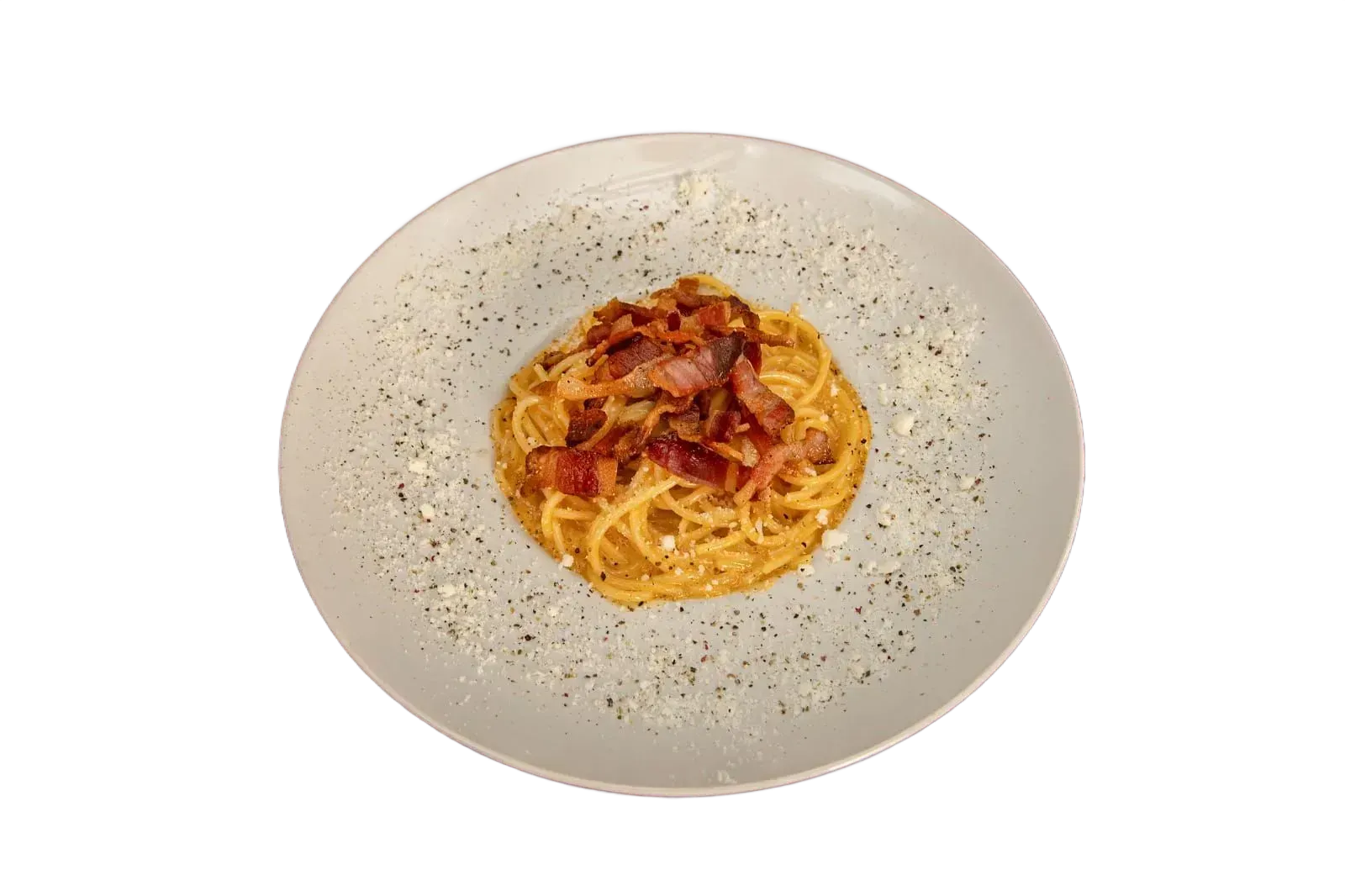 Espaguetis a la carbonara en un plato blanco, cubiertos con tocino y espolvoreados con pimienta.