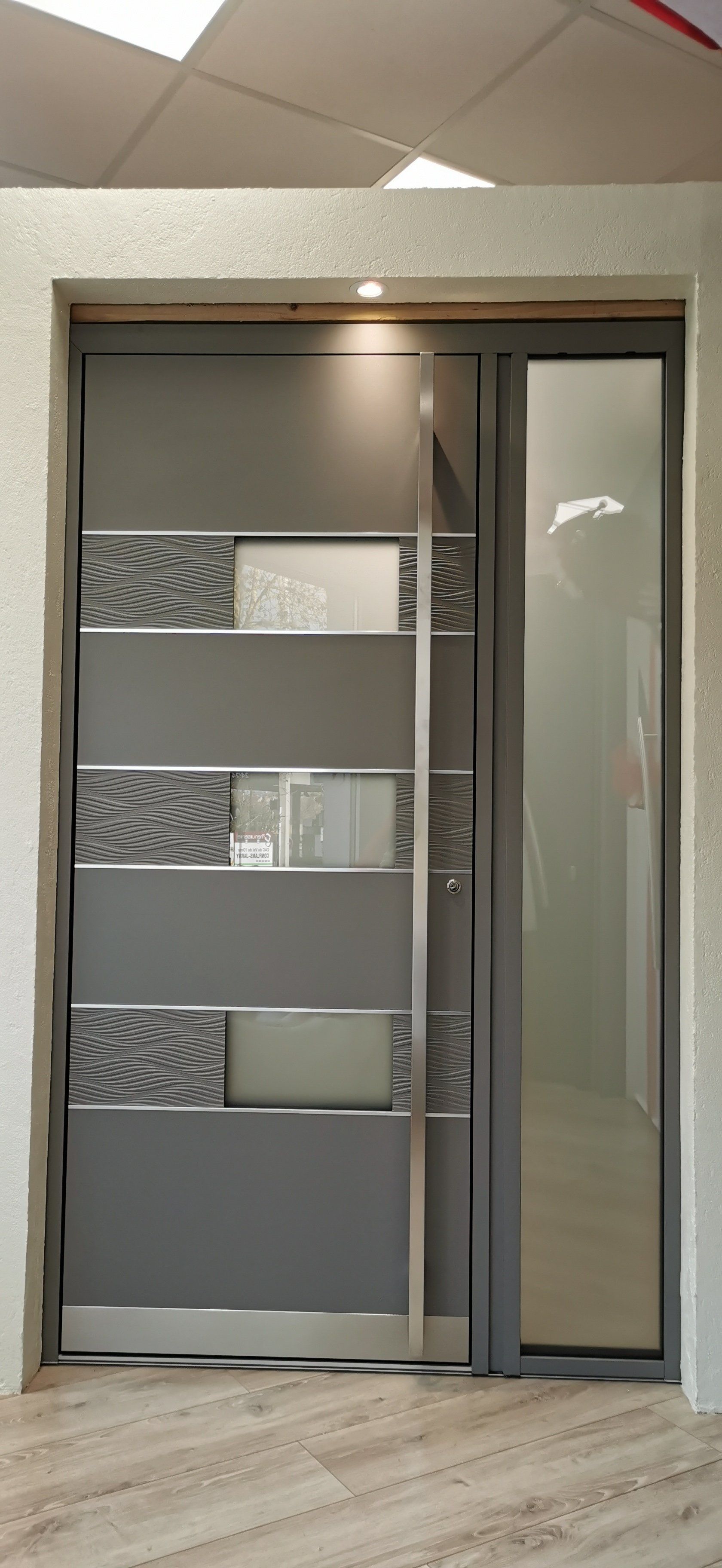 Porte d'entrée grise design avec parties en verre au centre