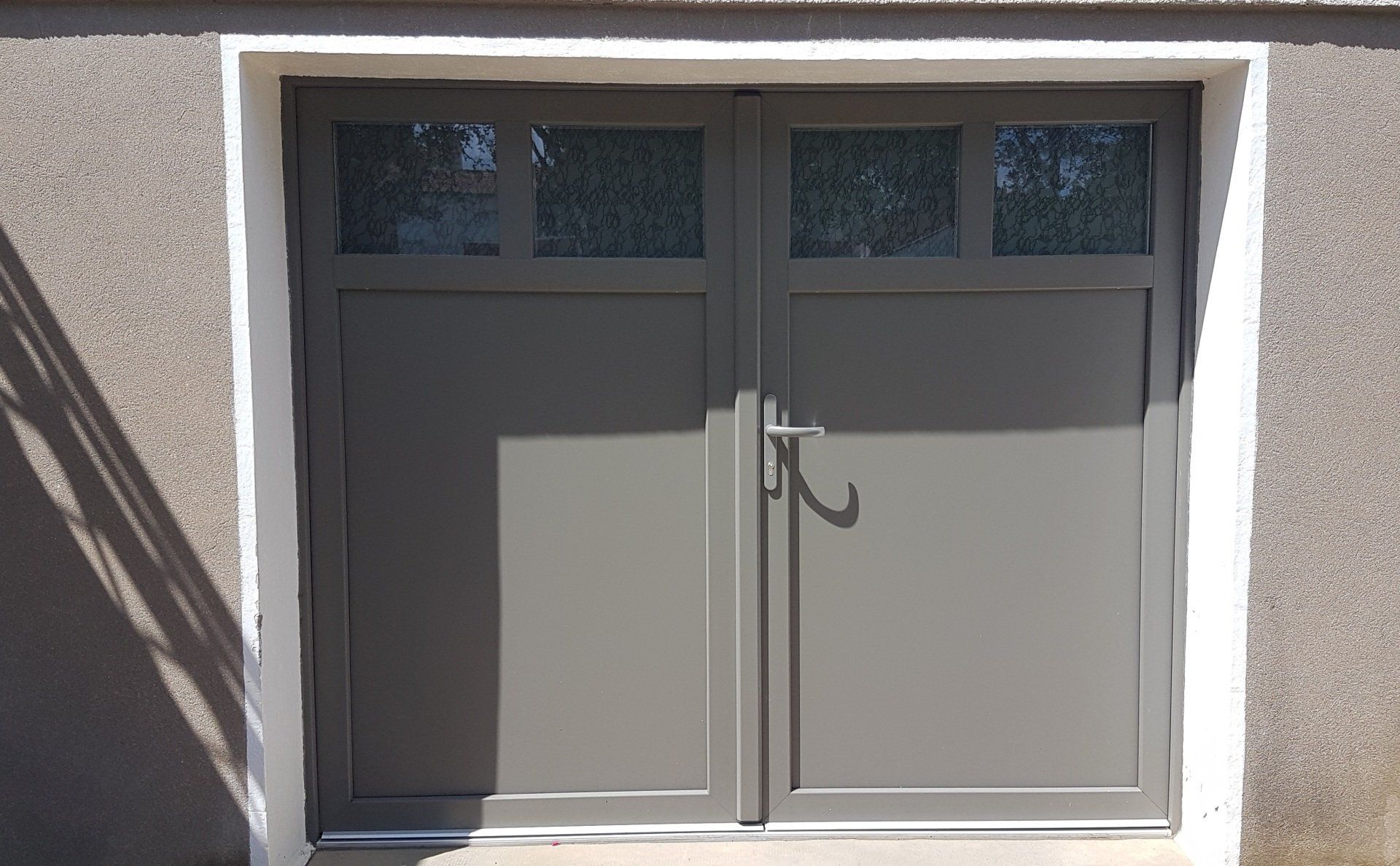 Porte de garage à porte battante de couleur gris