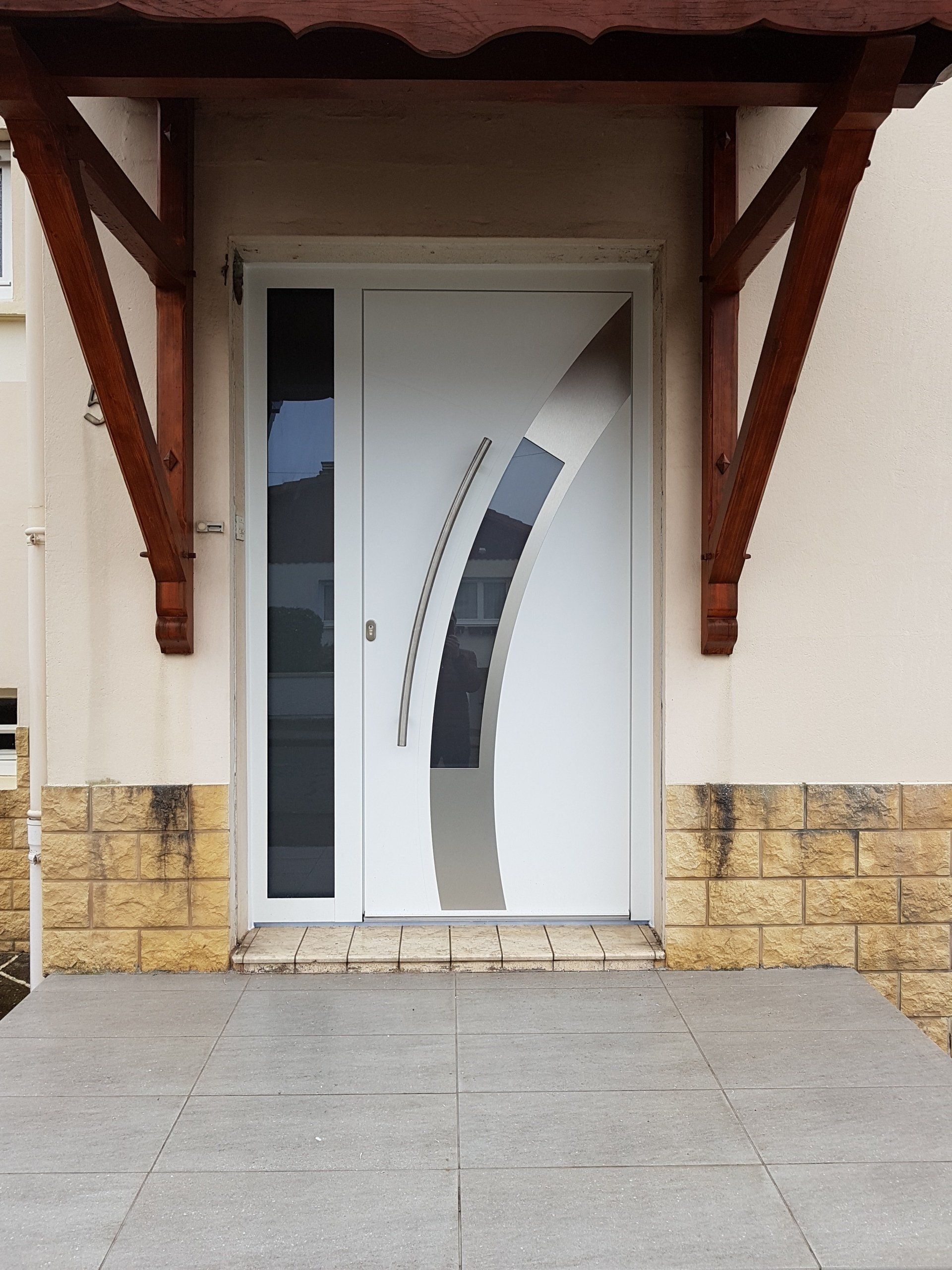 Porte d'entrée blanche avec des fenêtres arrondie et vertical incrusté.