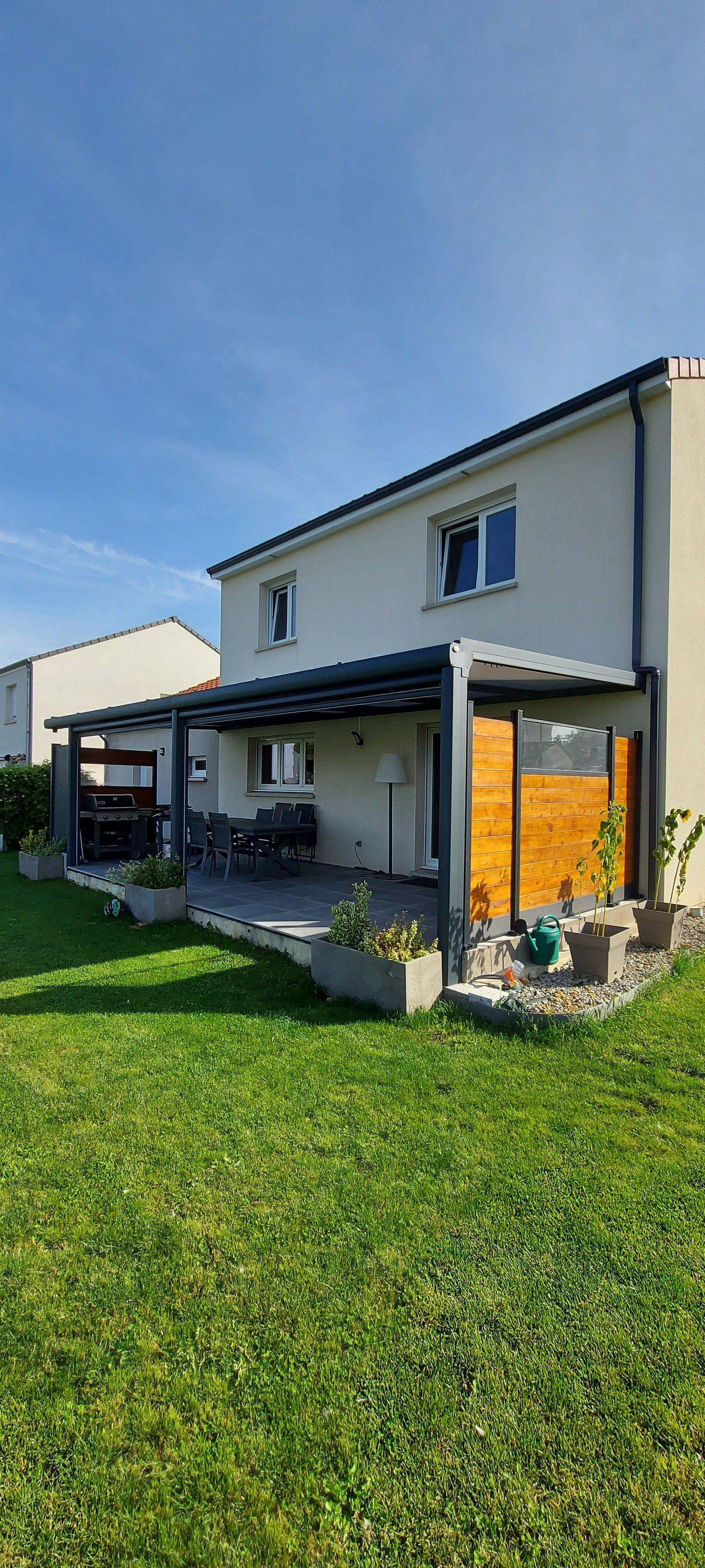 Pergola sombre avec cloison en bois à droite au bord de la terrasse