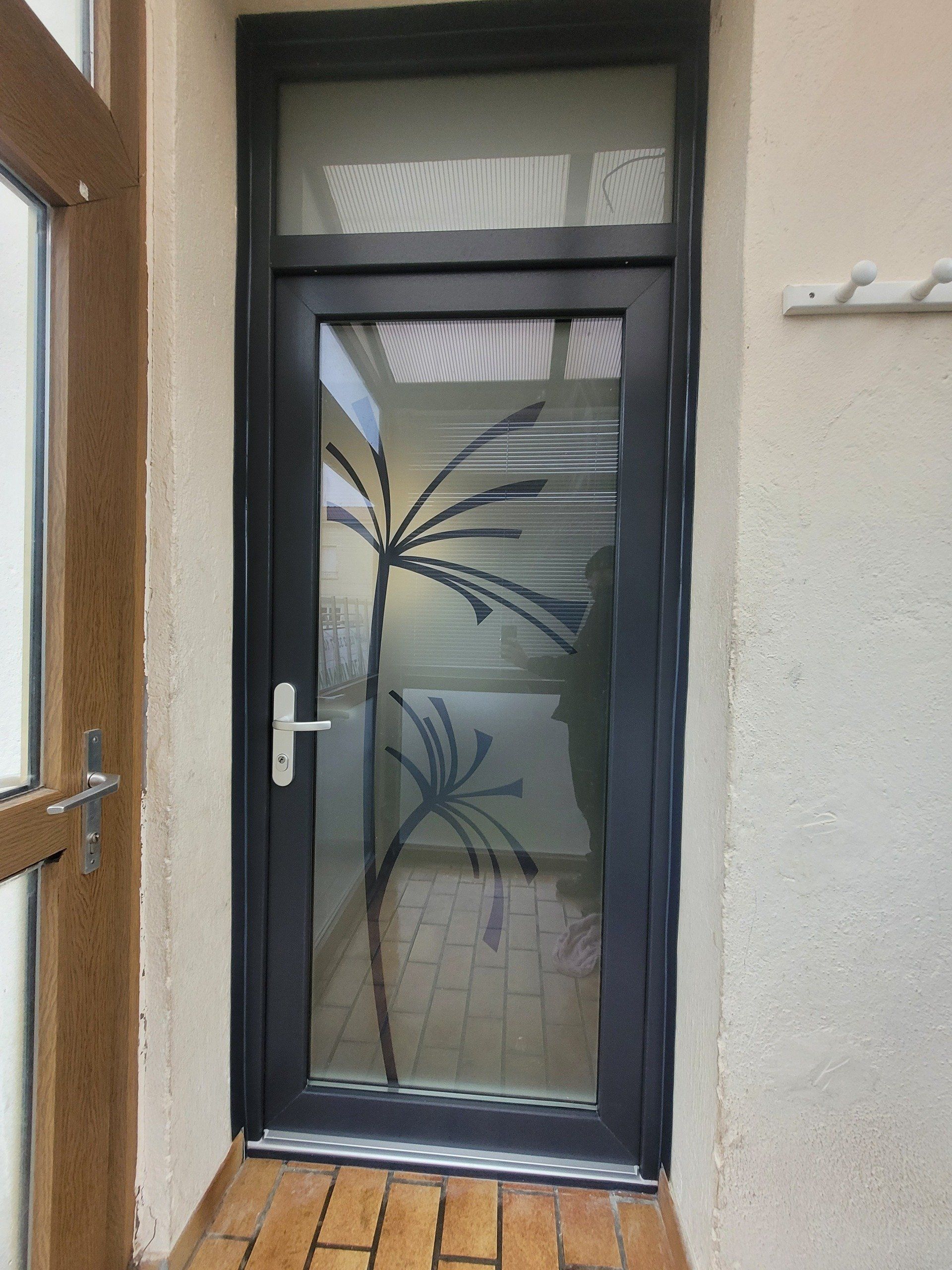 Porte d'entrée noire vitrée.