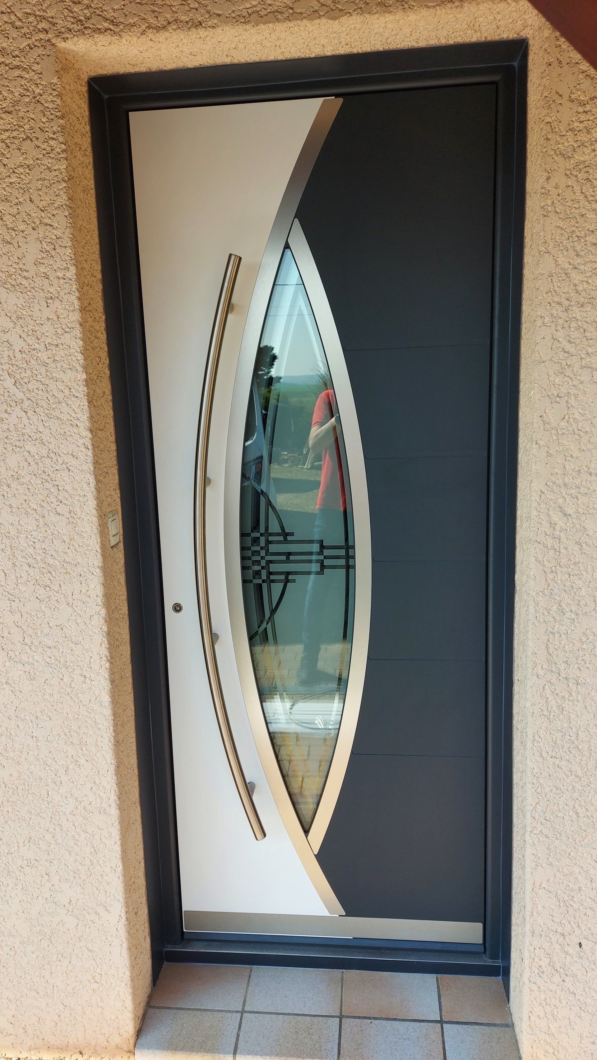 Porte en acier anthracite, dotée de détails géométriques modernes.