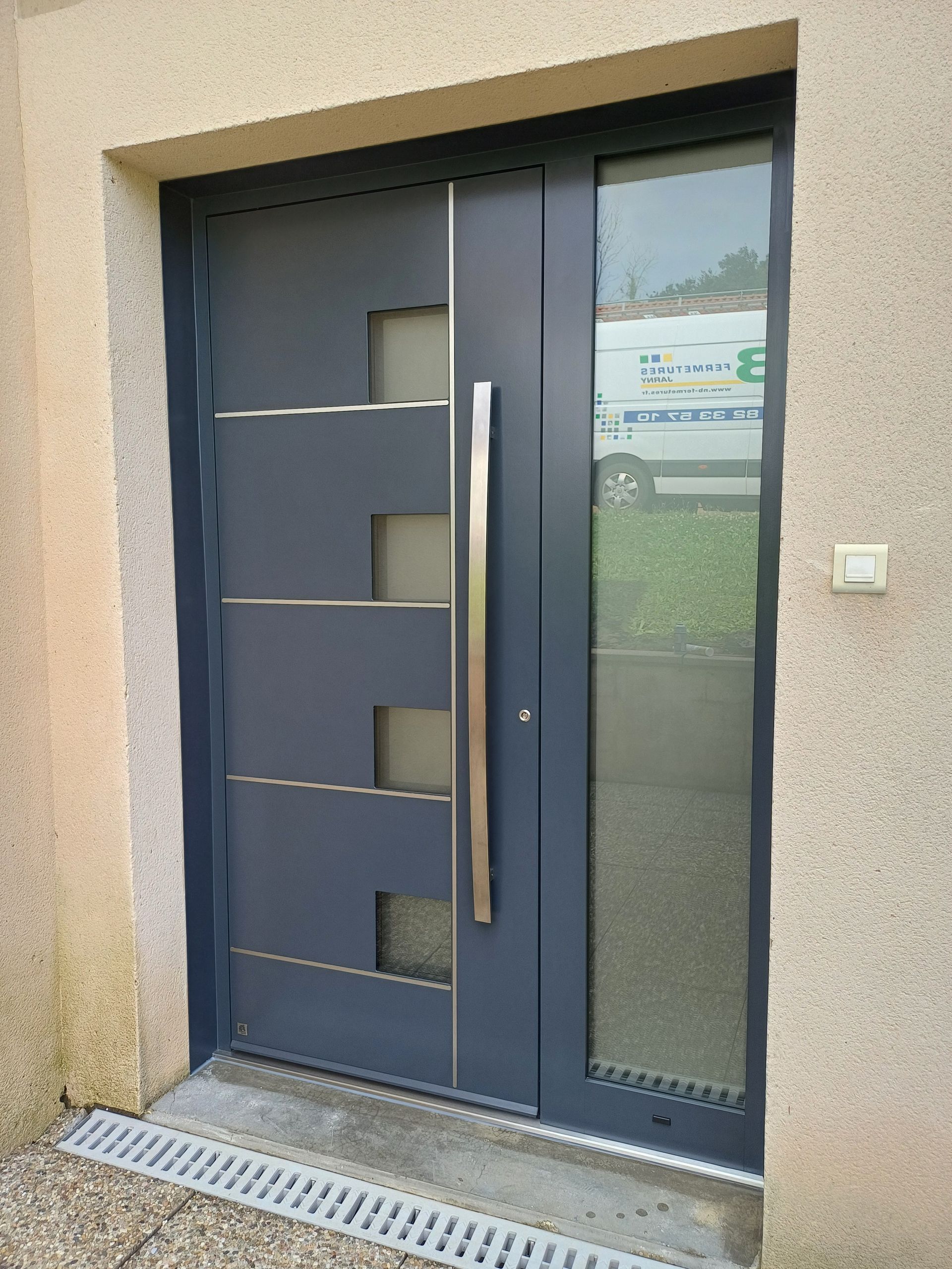 Grande porte d'entrée moderne avec des formes et sculpture en bronze dessus