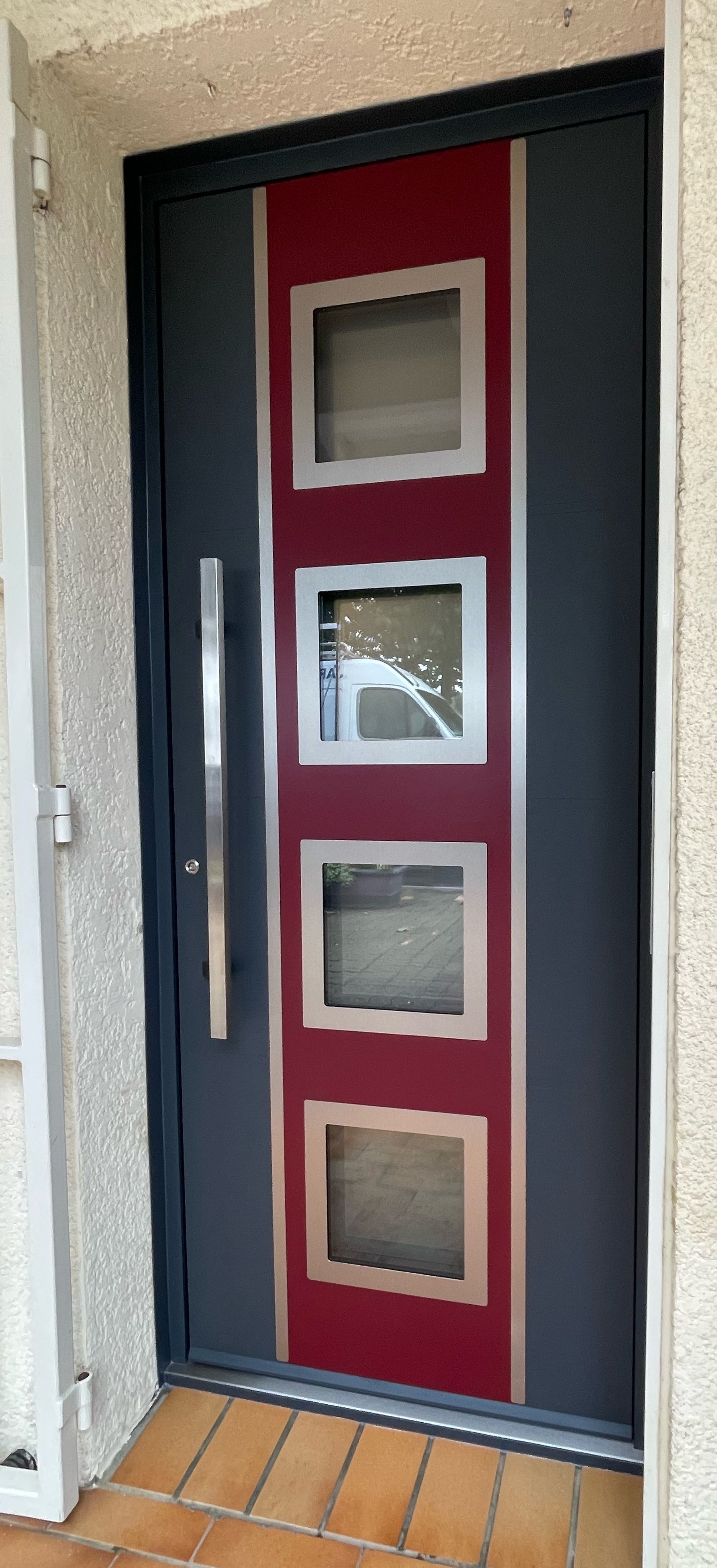 Porte moderne noir et blanc encastré dans un bloc béton et escalier devant