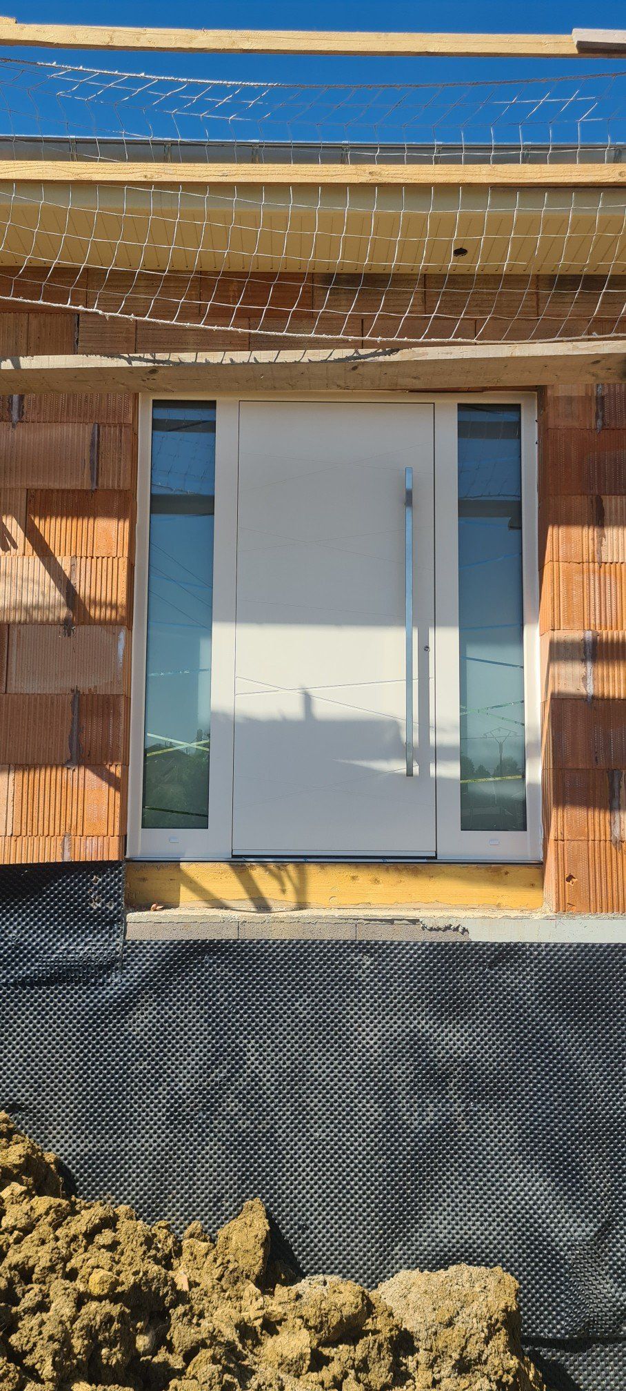 Porte d'entrée blanche avec parois de verre à gauche et à droite