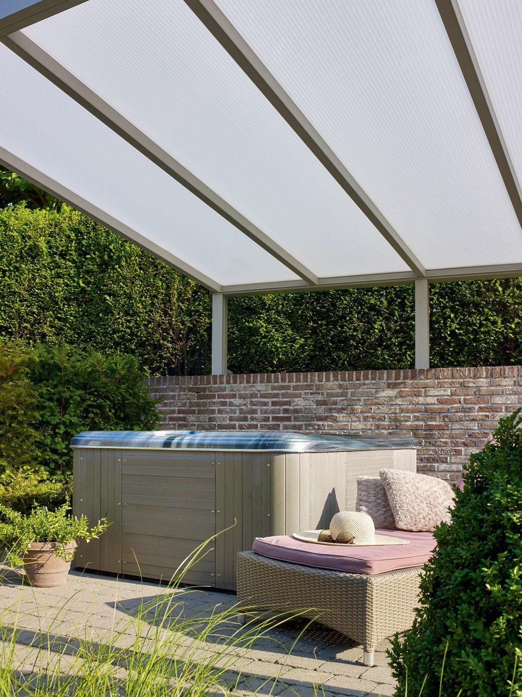 Pergola métallique grise aux panneaux blancs installés en biais au sessus d'un jacuzzi extérieur