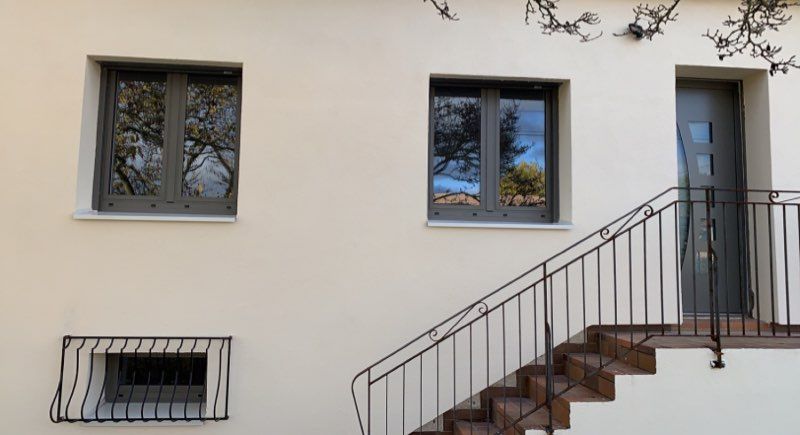 Fenêtre et porte d'entrée assortie avec un escalier devant la maison
